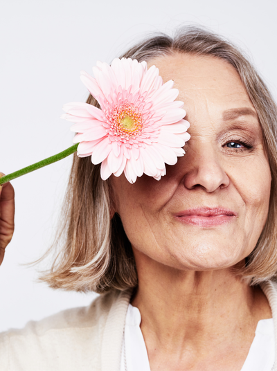 mujer con una flor rosa en la cara