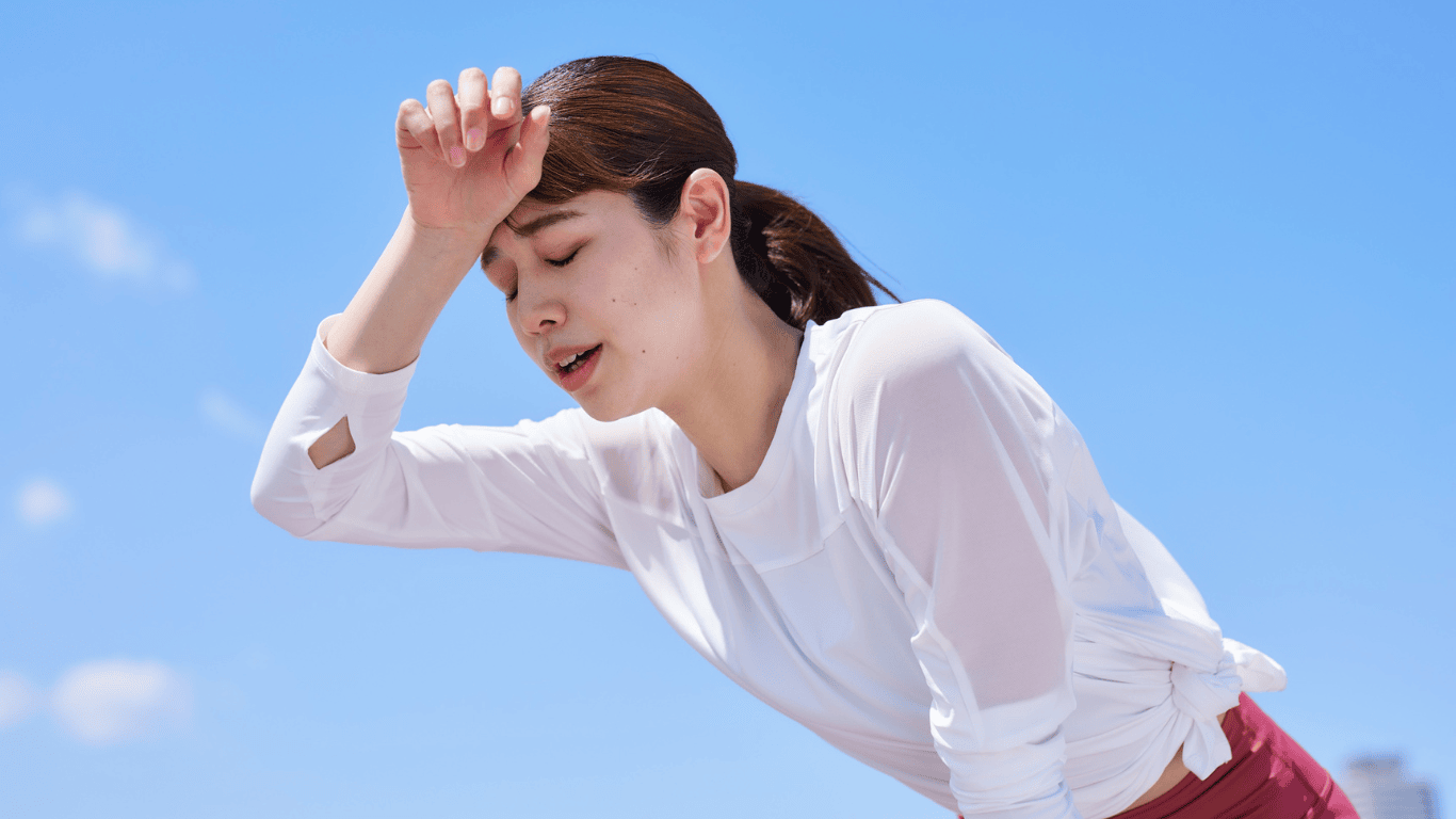 Chica frotandose el sudor de la frente por el calor